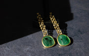 Gold drop earrings with a stunning large flat emerald at the end.
